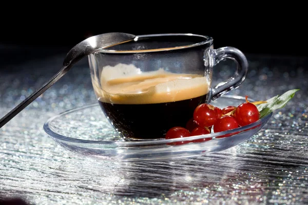 Espresso cofee with currants on black glass table — Stock Photo, Image