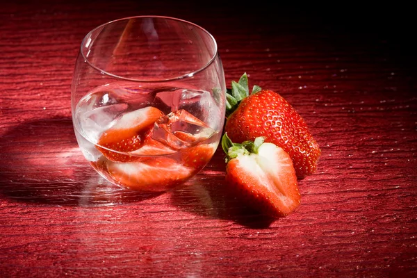 Foto Von Erdbeeren Auf Eis Auf Rotem Tisch — Stockfoto