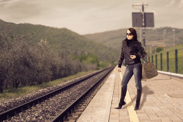 在其列车火车车站等的年轻女人的照片 — 图库照片