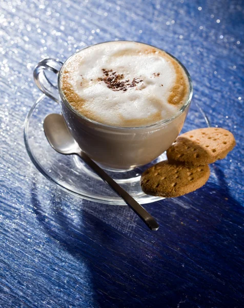 Cappuccino on blue glass table — Stock Fotó