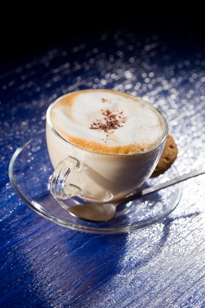 Cappuccino na mesa de vidro azul — Fotografia de Stock