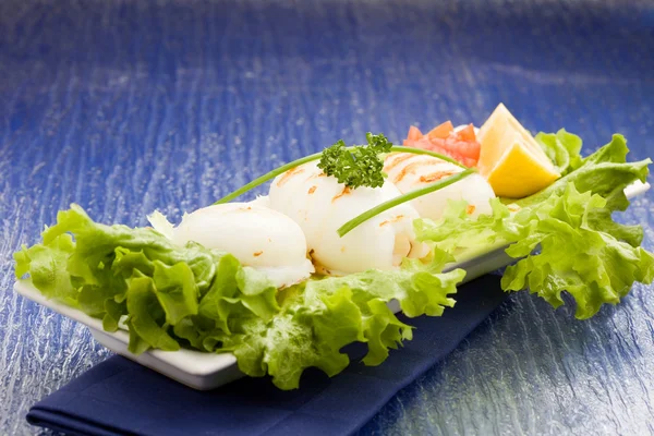 Кальмар з салатом на синьому скляному столі — стокове фото