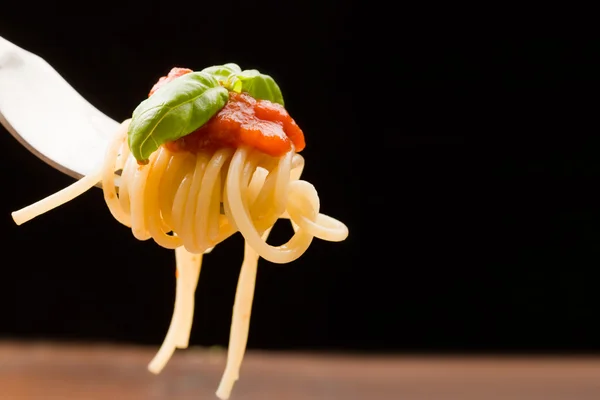 Spaghetti mit Tomatensauce und Basilikum auf Gabel gewickelt — Stockfoto