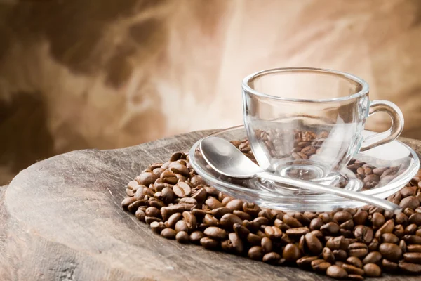 Copo de vidro vazio em grãos de café — Fotografia de Stock