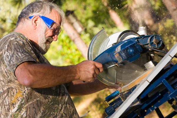 Homem sênior usando uma serra circular — Fotografia de Stock