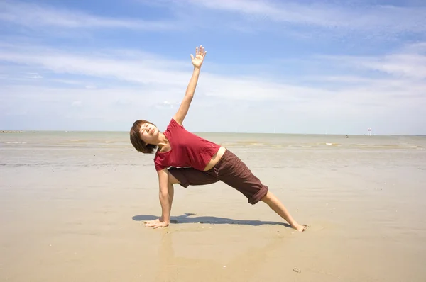 Asyalı kız sahilde Yoga gerçekleştirme — Stok fotoğraf