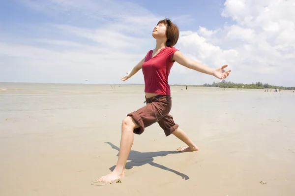 アジアの女の子がビーチでヨガを実行します。 — ストック写真