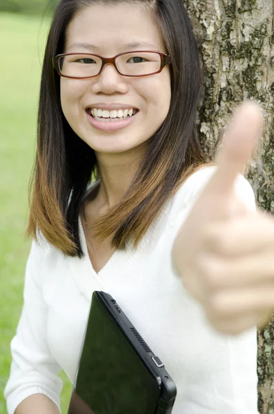 Азиатская девушка показывает большие пальцы вверх — стоковое фото