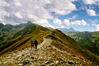 iki adam sırt çantaları ve kayalık dağ manzaralı dik tepeye hiking