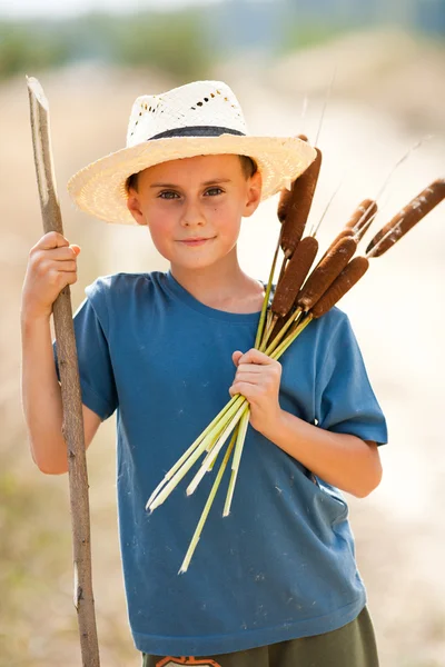 Hasır şapka bulrush ile oynayan çocuk — Stok fotoğraf