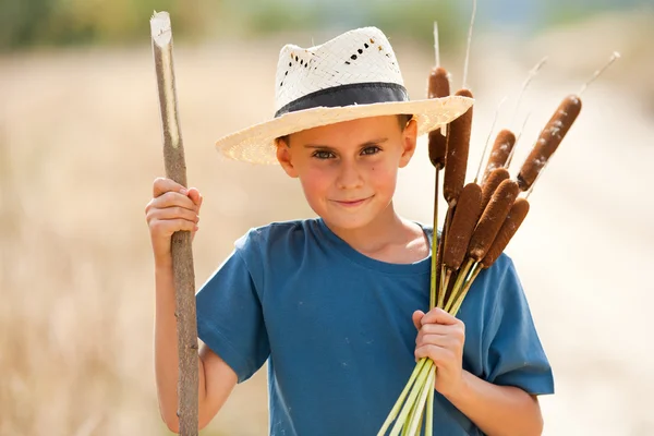 Enfant avec chapeau de paille jouant avec le scirpe — Photo