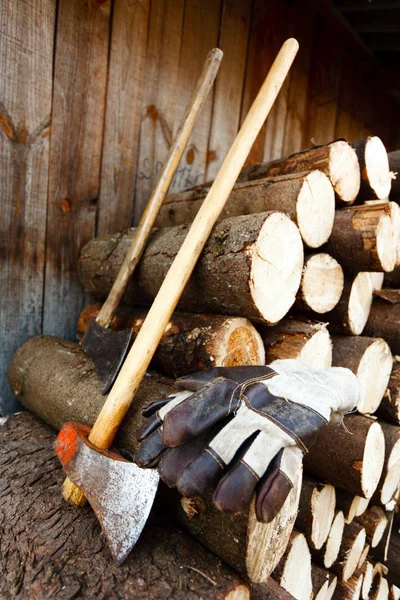Ascia, guanti protettivi e pile di tronchi — Foto Stock