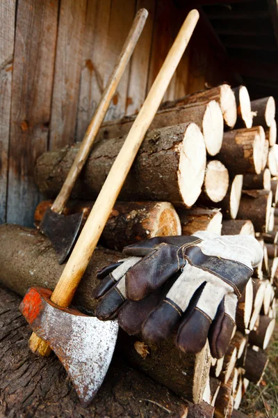 Ascia, guanti protettivi e pile di tronchi — Foto Stock