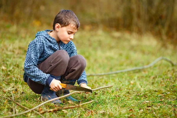 Child using handsaw to craft some toys Stock Photo