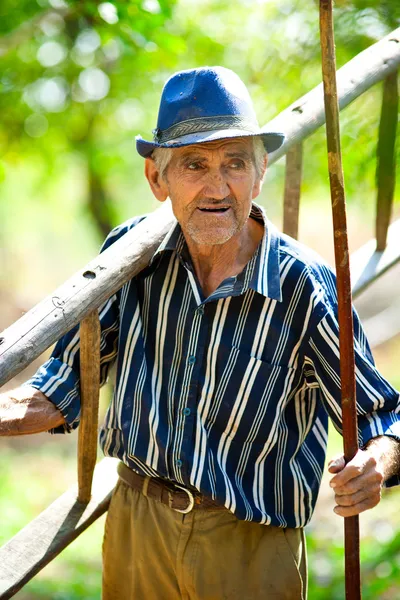 Starý farmář s nástroji — Stock fotografie