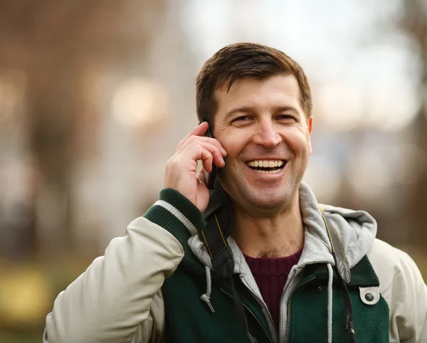 屋外の電話で話す若い男 — ストック写真