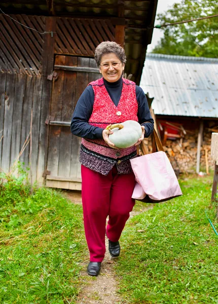 Alte Landfrau mit Kürbis im Freien — Stockfoto
