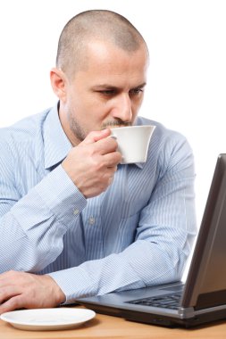 Businessman with coffee reading on computer screen clipart