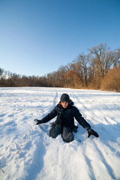 Criança feliz brincando na neve — Fotografia de Stock