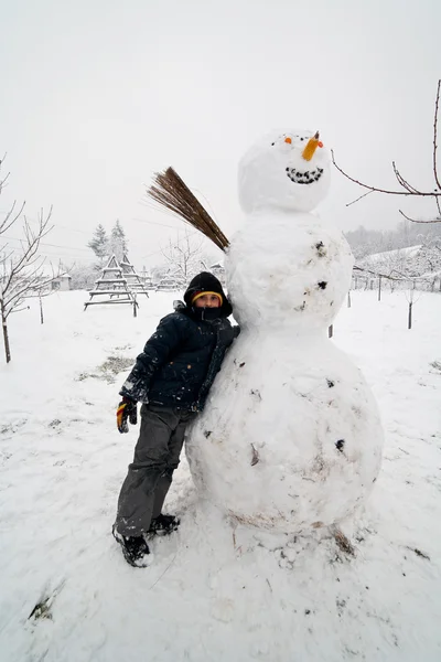 Παιδί Κοντά Ένα Μεγάλο Χιονάνθρωπο Ένα Χειμερινό Τοπίο — Φωτογραφία Αρχείου
