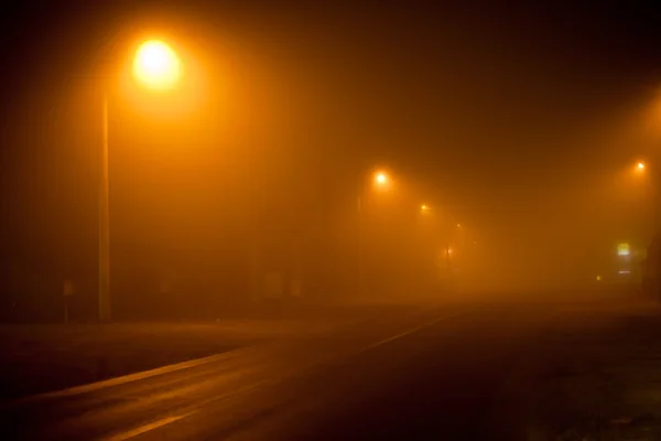 stock image Road at night with extremely dense fog and yellow street lamps