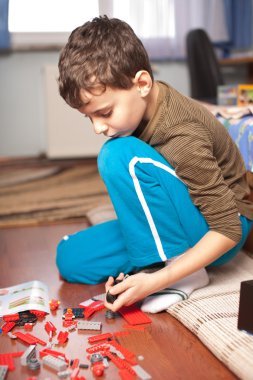 Kid playing with toys indoor, in his room