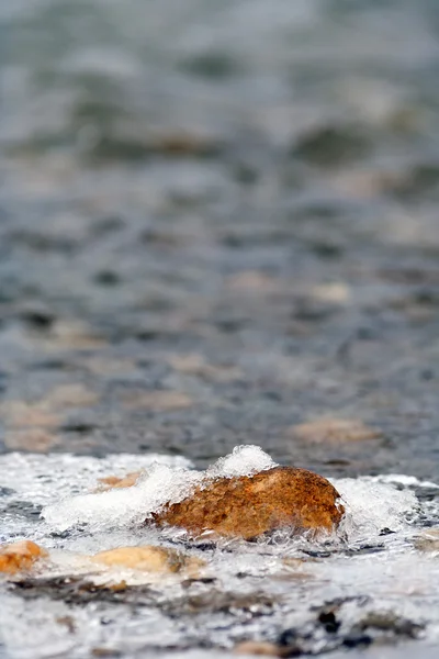 フィールドの浅い深さで川の近くの冷凍岩のマクロ — ストック写真