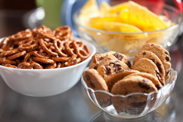 Cookies and pretzels in bowls, shallow DOF — Stock Photo, Image