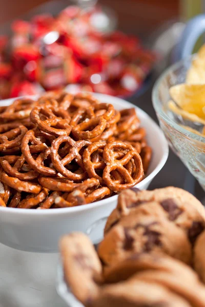 Cookies and pretzels in bowls, shallow DOF — Stock Photo, Image