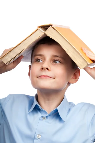Skolpojke med en bok på huvudet — Stockfoto