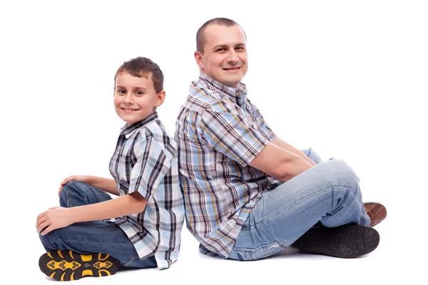 Padre e hijo sentados espalda con espalda — Foto de Stock