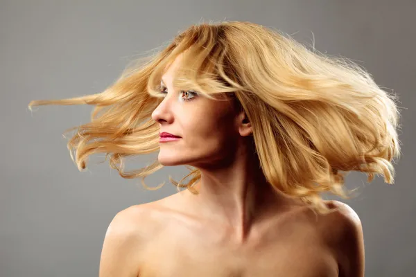 Blonde Dame, die ihre Haare umdreht — Stockfoto