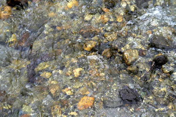 Stock image Colouful pebbles visible under transparent layer of clear water