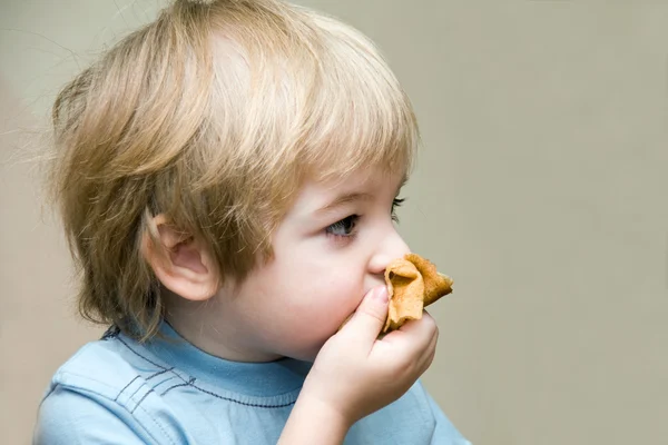 Kleine blonde jongen die pannenkoeken eet — Stockfoto