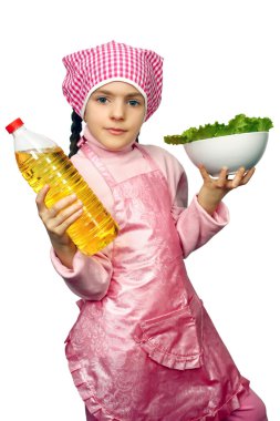 Girl in an apron with the dish of lettuce and sunflower-seed