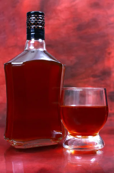 La bebida alcohólica está en una botella y un vaso. — Foto de Stock