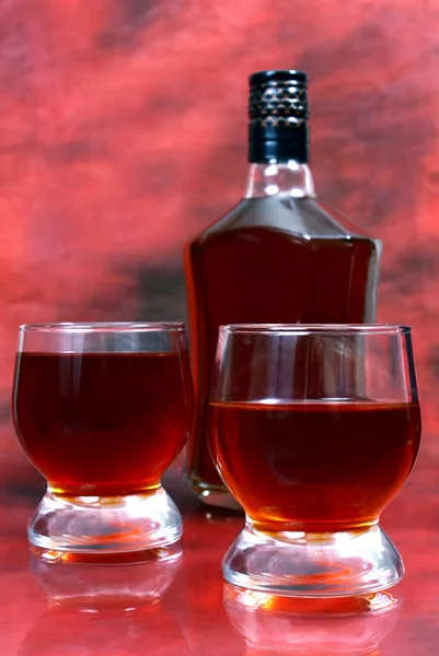 La bebida alcohólica está en una botella y un vaso. —  Fotos de Stock