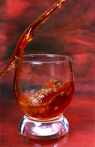 Bebida alcoólica derramando em vidro — Fotografia de Stock