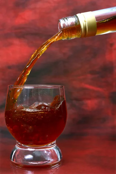 Alcohol drink pouring into glass — Stock Photo, Image