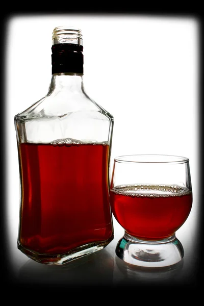 La bebida alcohólica está en una botella y un vaso. —  Fotos de Stock
