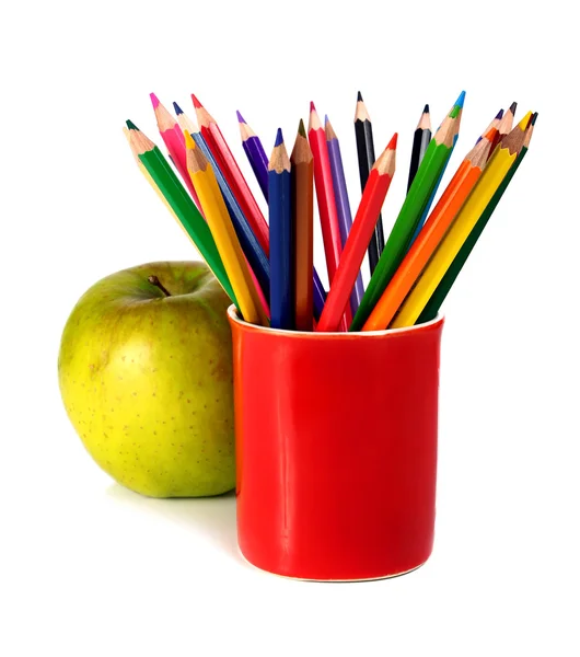 Färgade pennor och grönt äpple — Stockfoto
