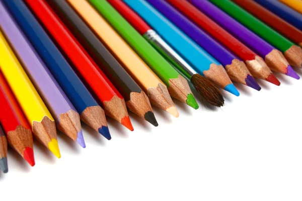 Crayons coloured pencils and brush for paints — Stock Photo, Image