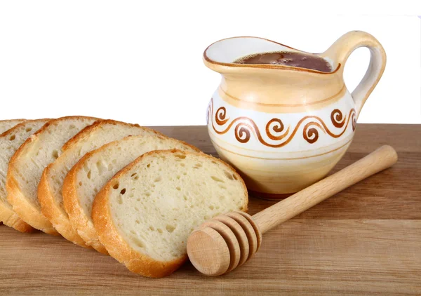 stock image Honey in a jug and loaf on board