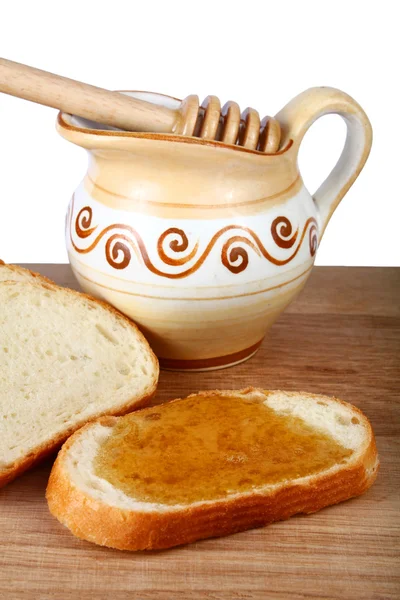Mel em um jarro e pão a bordo — Fotografia de Stock