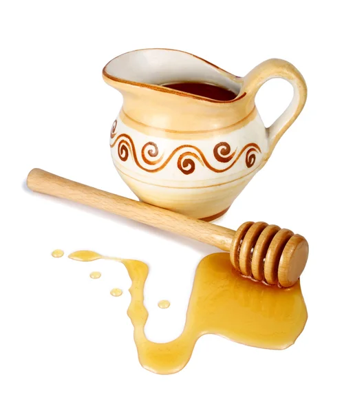 Honey in a jug and wooden stick — Stock Photo, Image