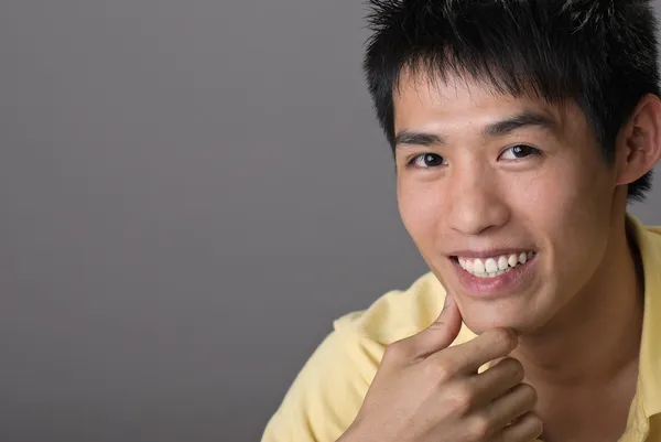 Улыбающийся азиатский юноша — стоковое фото