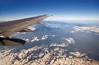 Altitude from the aircraft window to see the blue sky and white clouds view. clipart