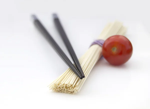 Fideos japoneses con palillos y tomate cereza aislados en gris —  Fotos de Stock