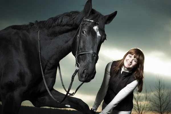 Gyönyörű fiatal nő, egy fekete ló — Stock Fotó