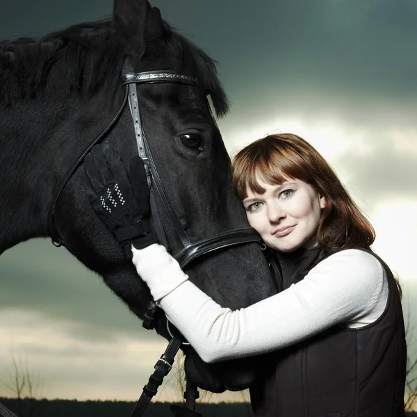 Krásná mladá žena s černým koněm — Stock fotografie